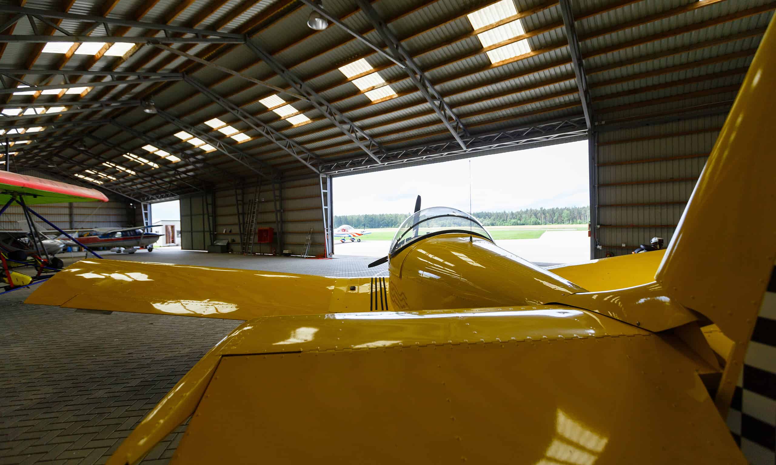 Small airplane parked in an outdoor aircraft shed