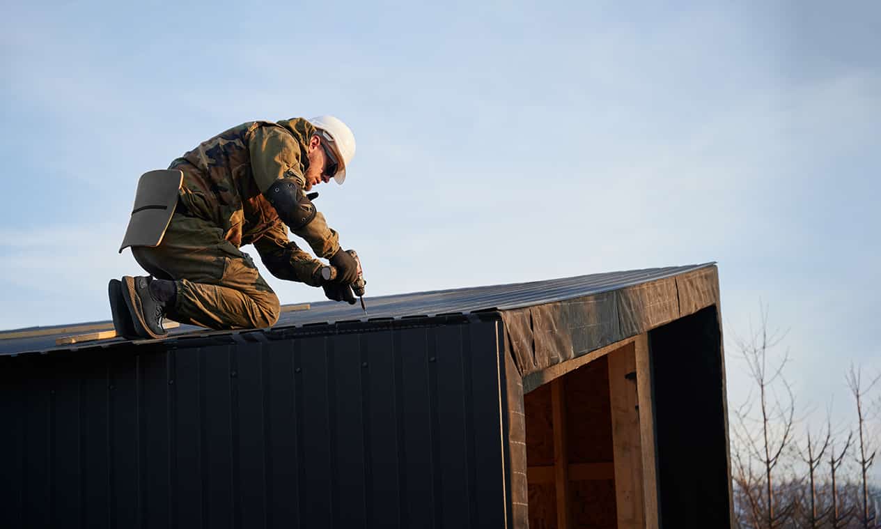 Professional builder expertly installing a new roof on a residential house