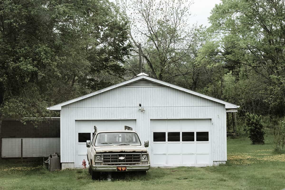 "Modern suburban house showcasing a spacious detached garage and beautifully manicured front lawn"